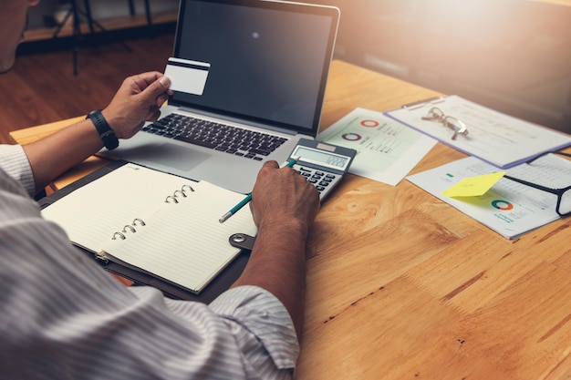 A person using a laptop and calculator to estimate their taxes, depicting the process of tax planning and financial management.
