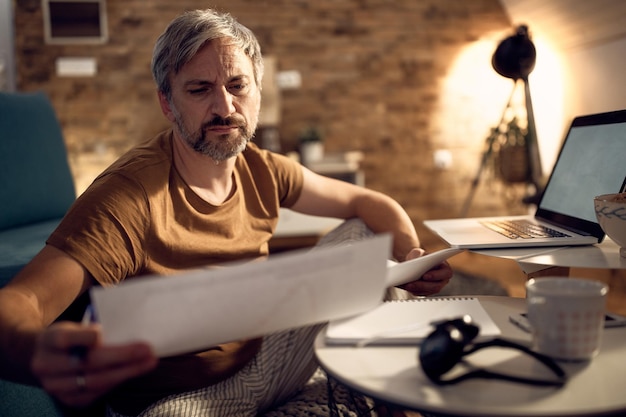 A person looking through old financial documents, with a magnifying glass, in a cluttered home office, searching for information on old or forgotten retirement accounts. Focus on the search and investigation aspect.